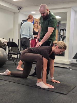 DNS instructor cueing shoulder position during bear-position correction at DNS Exercise Part II, Elevate LDN