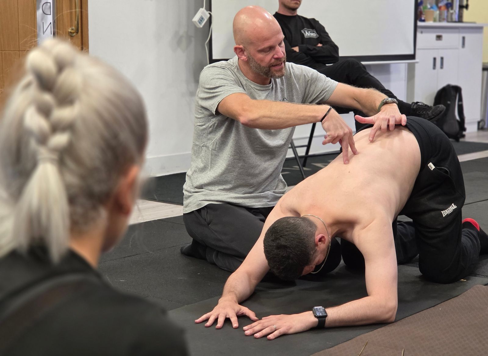 DNS instructor correcting prone developmental position during exercise course at Elevate LDN