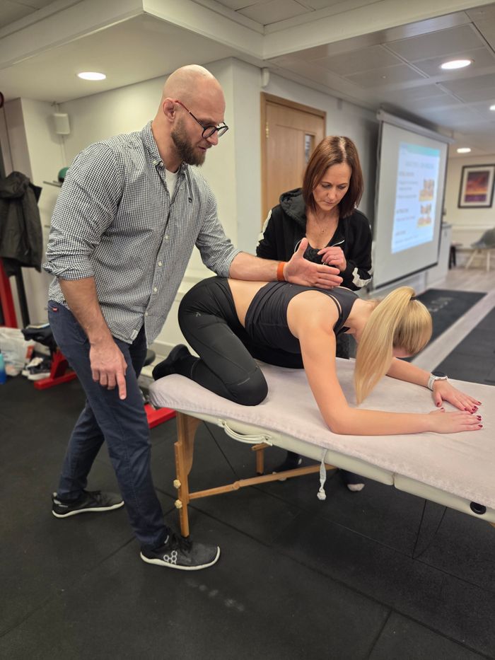 Łukasz Burliński overseeing prone assessment on treatment table during DNS Exercise course at Elevate LDN