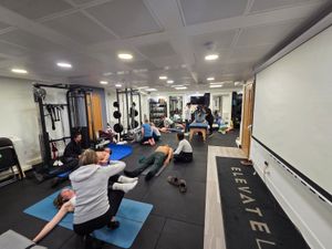 Course attendees practising DNS floor exercises in pairs at Elevate LDN studio