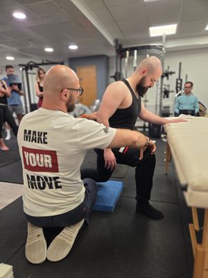 DNS instructor assisting side-lying resistance band exercise during Part II at Elevate LDN