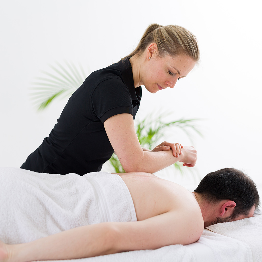 woman massaging a man on a massage table